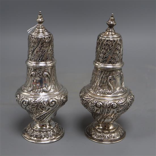 A pair of Edwardian repousse silver sugar casters, Sibray, Hall & Co, London, 1903/4, 20cm, 12.5 oz.